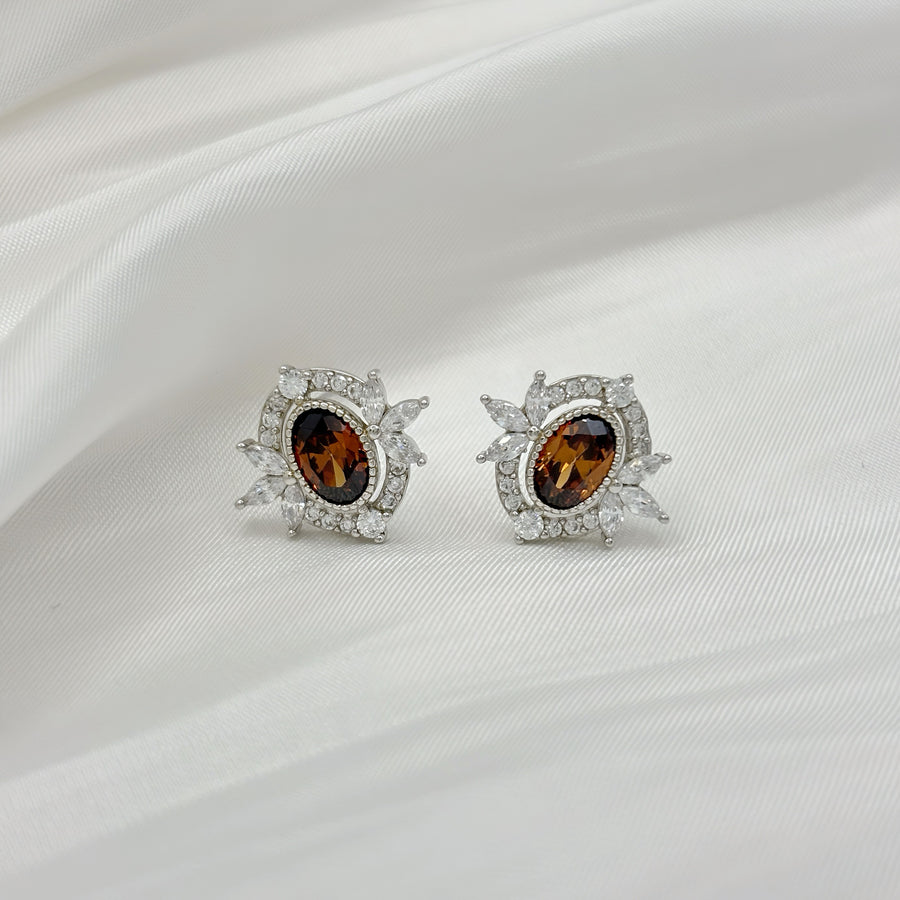 925 silver earrings. Add a touch of warmth and sparkle with these exquisite stud earrings, featuring rich amber-hued gemstones framed by radiant cubic zirconia. Perfect for bringing timeless sophistication to your everyday or evening look. 