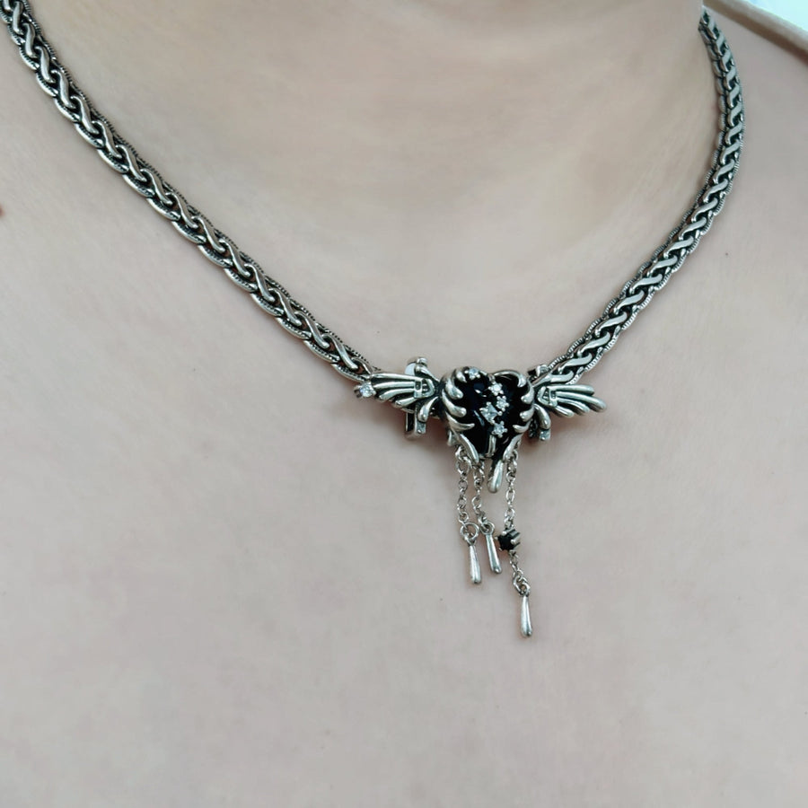 This necklace is a stunning piece of jewelry made from pure silver with a black heart-shaped angel design. It is adorned with glistening cubic zirconia that add a touch of brilliance.