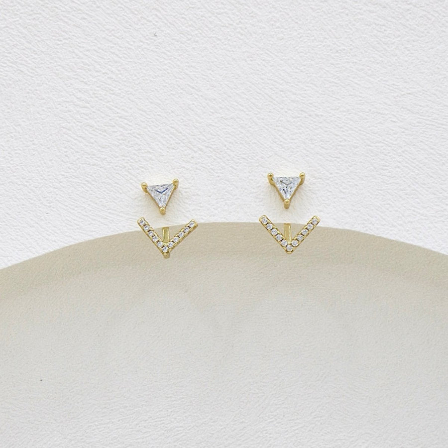 These elegant gold earrings feature a unique design with a triangular cubic zircon at the top and a V-shaped lower part adorned with sparkling cubic zircon, offering a touch of sophistication and glamour to any outfit. The combination of geometric shapes and shimmering accents makes these earrings a stylish and eye-catching accessory for any occasion.