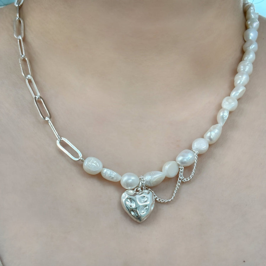 A delicate fusion of classic and contemporary—a freshwater pearl strand meets bold silver links, complete with a charming heart pendant for a touch of romance. 