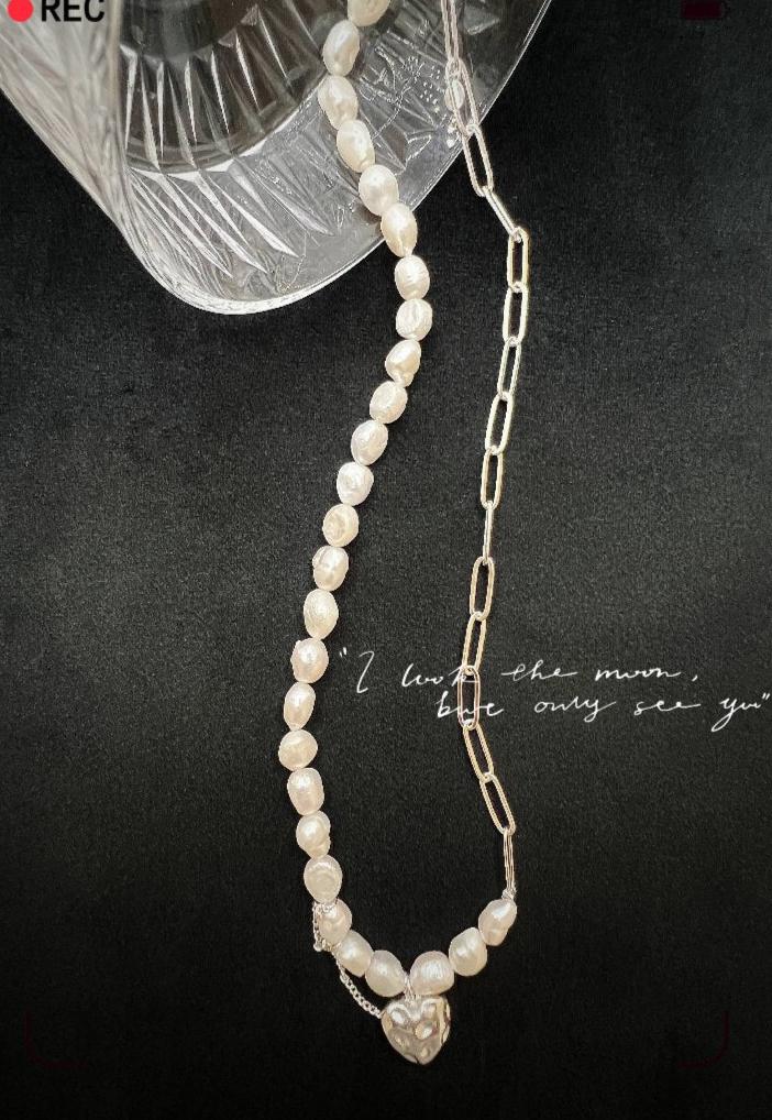 A delicate fusion of classic and contemporary—a freshwater pearl strand meets bold silver links, complete with a charming heart pendant for a touch of romance. 