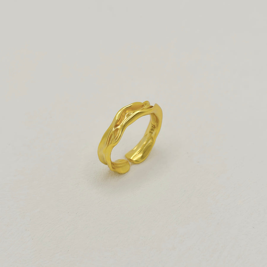 The ring features a fluid, wave-inspired design, crafted from premium 925 silver with a radiant gold plating for timeless elegance. Perfect for any occasion, this adjustable ring adds a touch of sophistication and modern charm to your everyday style.