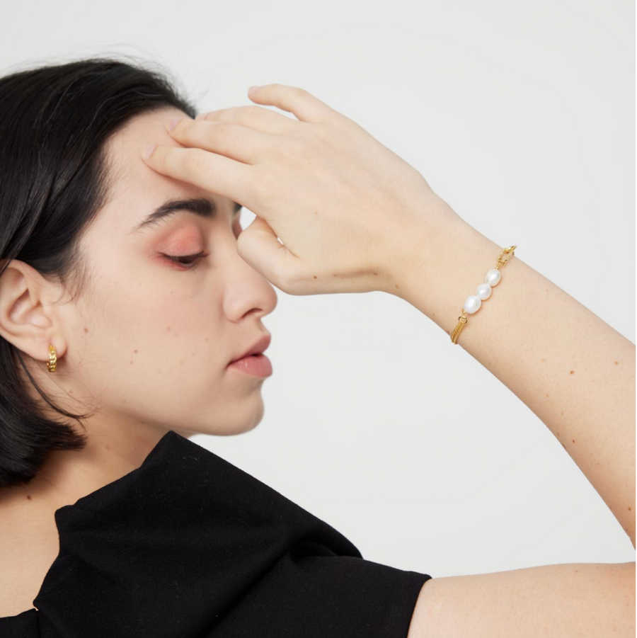 This modern gold vermeil bracelet features a unique combination of bold gold chains and natural baroque pearls, offering a striking contrast of textures. Designed with a toggle clasp for easy wear, this piece adds a statement touch to both casual and formal outfits.