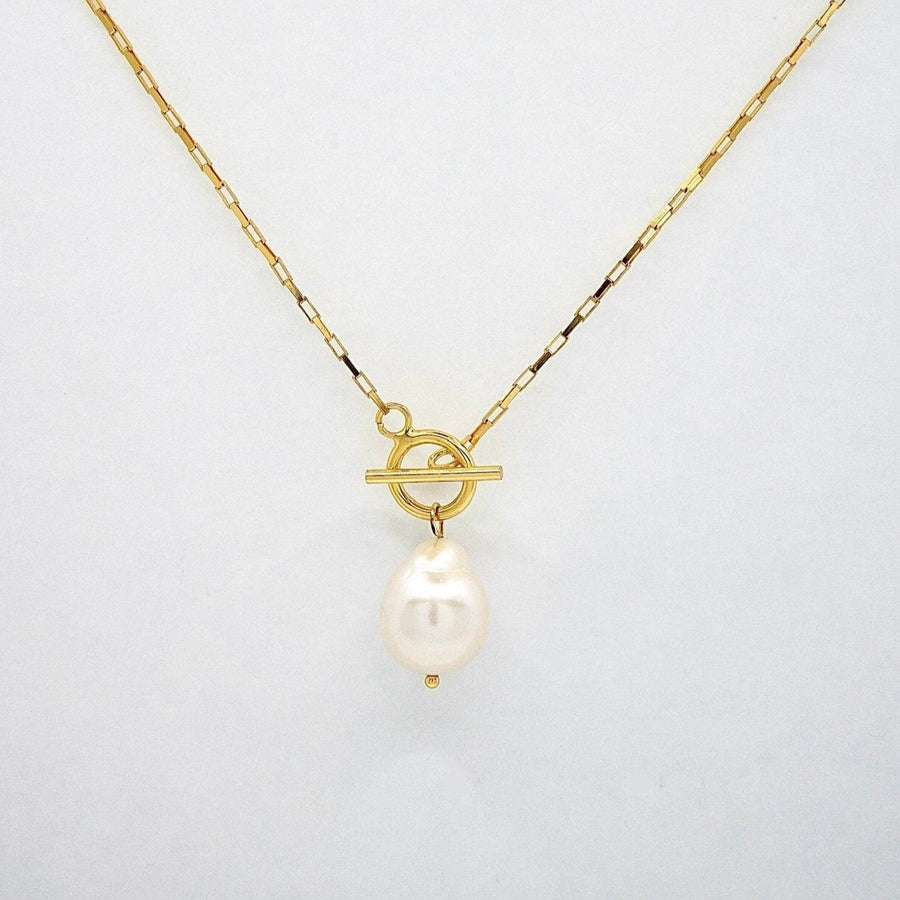 This necklace features a large, irregularly shaped baroque pearl pendant suspended from a gold chain. The chain has a toggle clasp with a circular ring and a horizontal bar, adding a stylish and functional element to the design. Perfect for both special occasions and everyday wear, this necklace combines the natural beauty of baroque pearls with contemporary elegance.