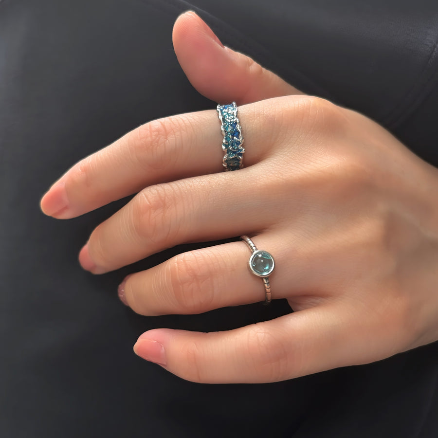 This wave-shaped silver ring, featuring a unique irregular texture and a stunning blue resin that adds a touch of sophistication and elegance to any outfit. Perfect for any occasion