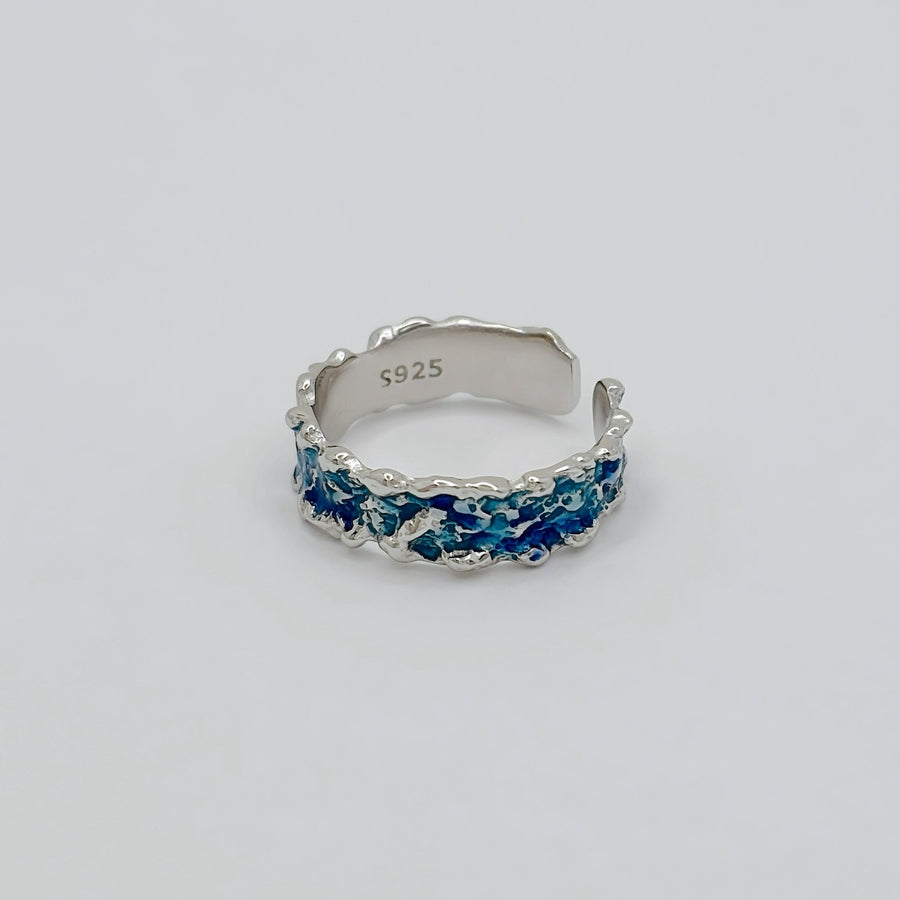 This wave-shaped silver ring, featuring a unique irregular texture and a stunning blue resin that adds a touch of sophistication and elegance to any outfit. Perfect for any occasion