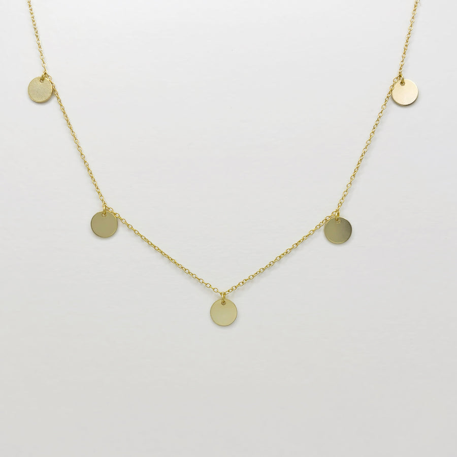 This dainty gold-plated silver necklace features delicate circular pendants, adding a touch of minimalistic charm to any outfit. Perfect for layering or wearing alone, this necklace complements both casual and formal looks effortlessly.