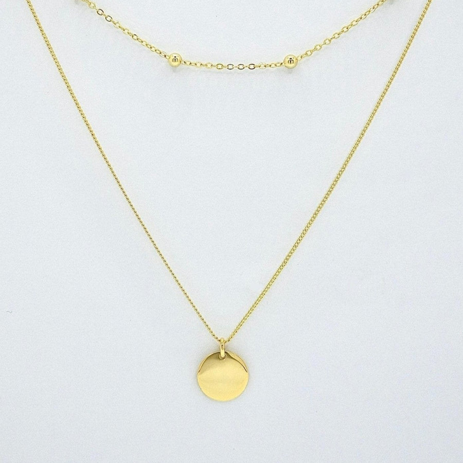 925 Sterling silver necklace. This layered gold necklace combines a sleek coin pendant with delicate bead accents, offering a chic and versatile accessory for any look. Effortlessly elegant, this double-layer design adds depth and charm to your style, perfect for both casual and formal occasions.