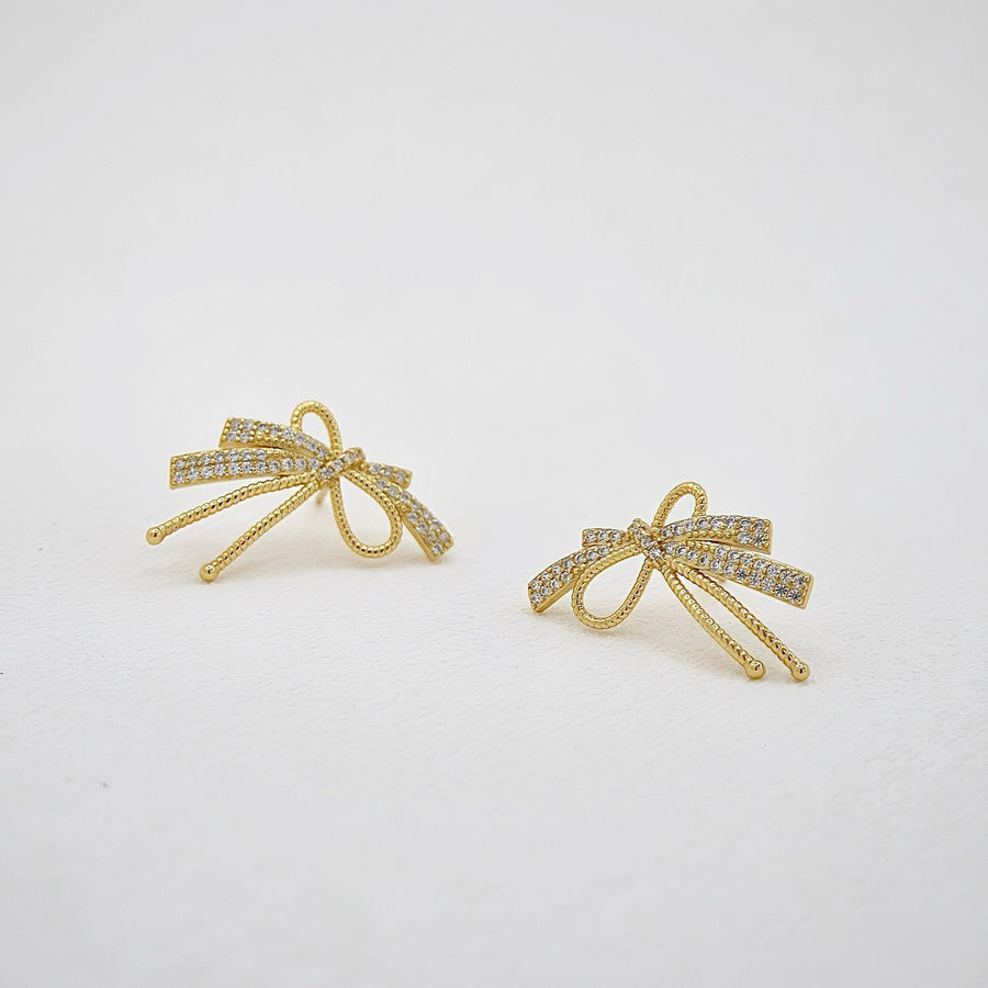 These exquisite earrings feature a delicate bow design crafted from high-quality silver. Each bow is adorned with sparkling cubic zircon, adding a touch of elegance and sophistication to any outfit. Perfect for special occasions or everyday wear, these earrings effortlessly enhance your style with their timeless charm. 