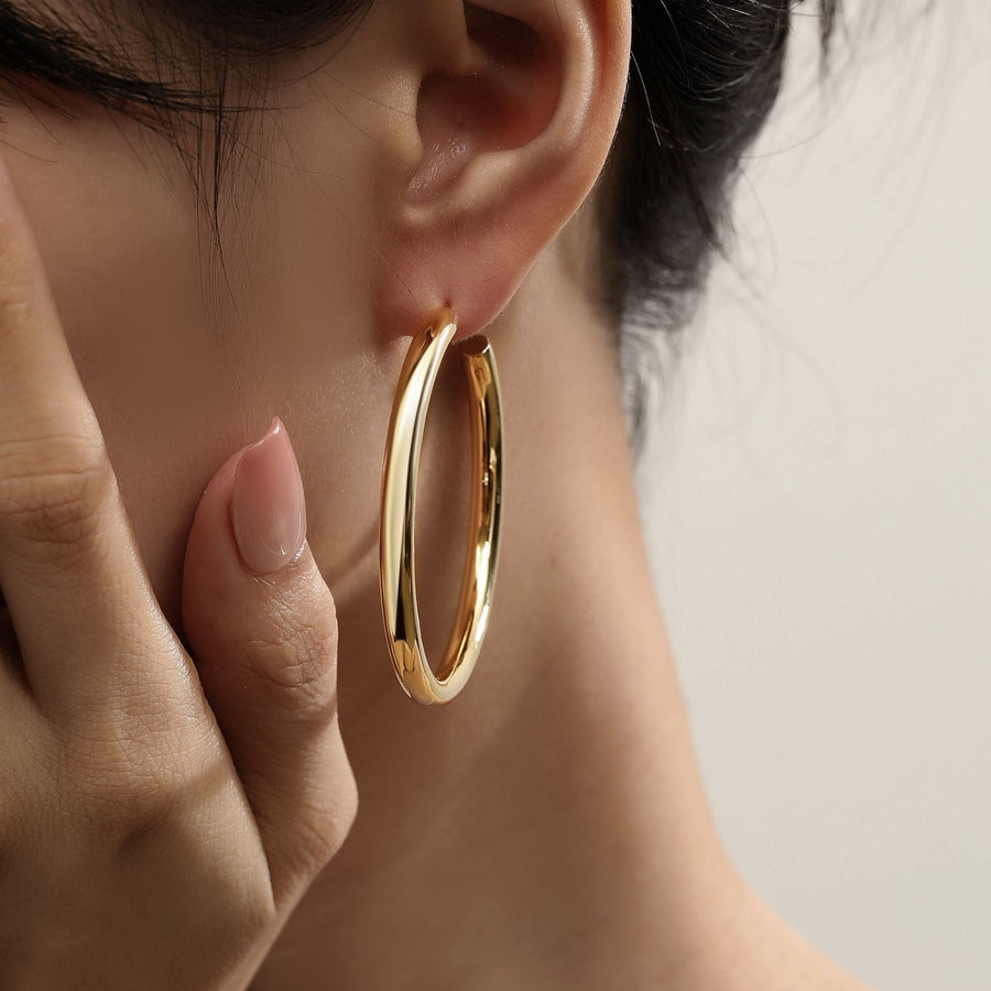 Make a bold statement with the hoop earrings, designed to complement any outfit with their timeless elegance. These large, minimalist hoops add a touch of sophistication to both casual and formal attire