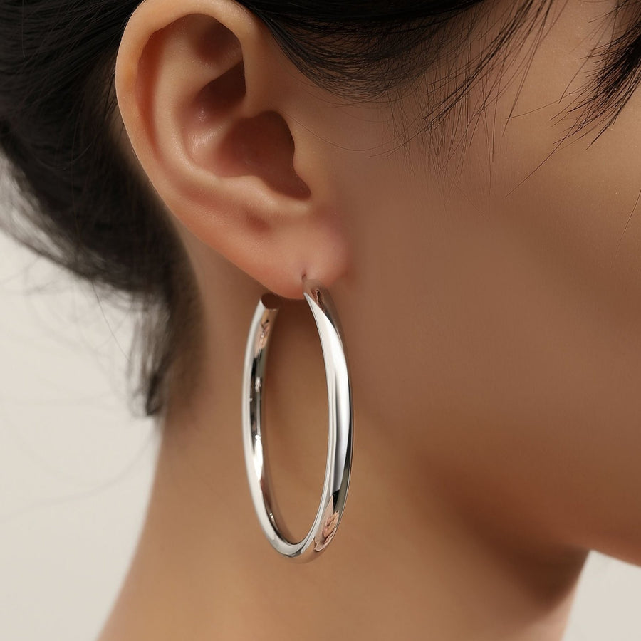 Make a bold statement with the hoop earrings, designed to complement any outfit with their timeless elegance. These large, minimalist hoops add a touch of sophistication to both casual and formal attire