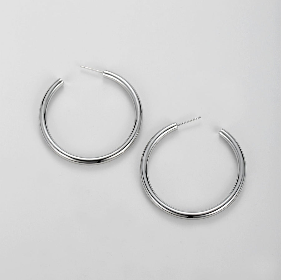 Make a bold statement with the hoop earrings, designed to complement any outfit with their timeless elegance. These large, minimalist hoops add a touch of sophistication to both casual and formal attire