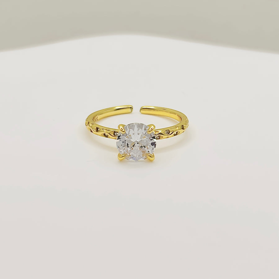 Gold vermeil Classic Ring. Featuring a brilliant round-cut cubic zircon set on a delicately textured gold band, this ring radiates timeless sophistication. 