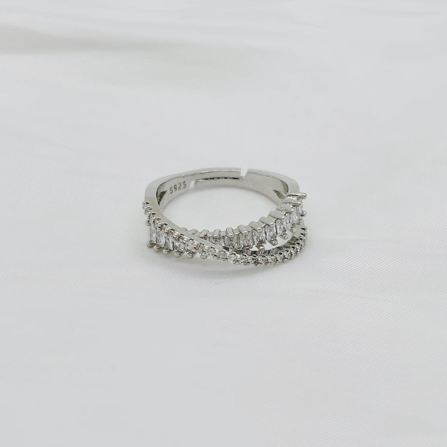 This dazzling sterling silver ring showcases an intricate layered design, adorned with rows of sparkling cubic zirconia for a luxurious touch. 