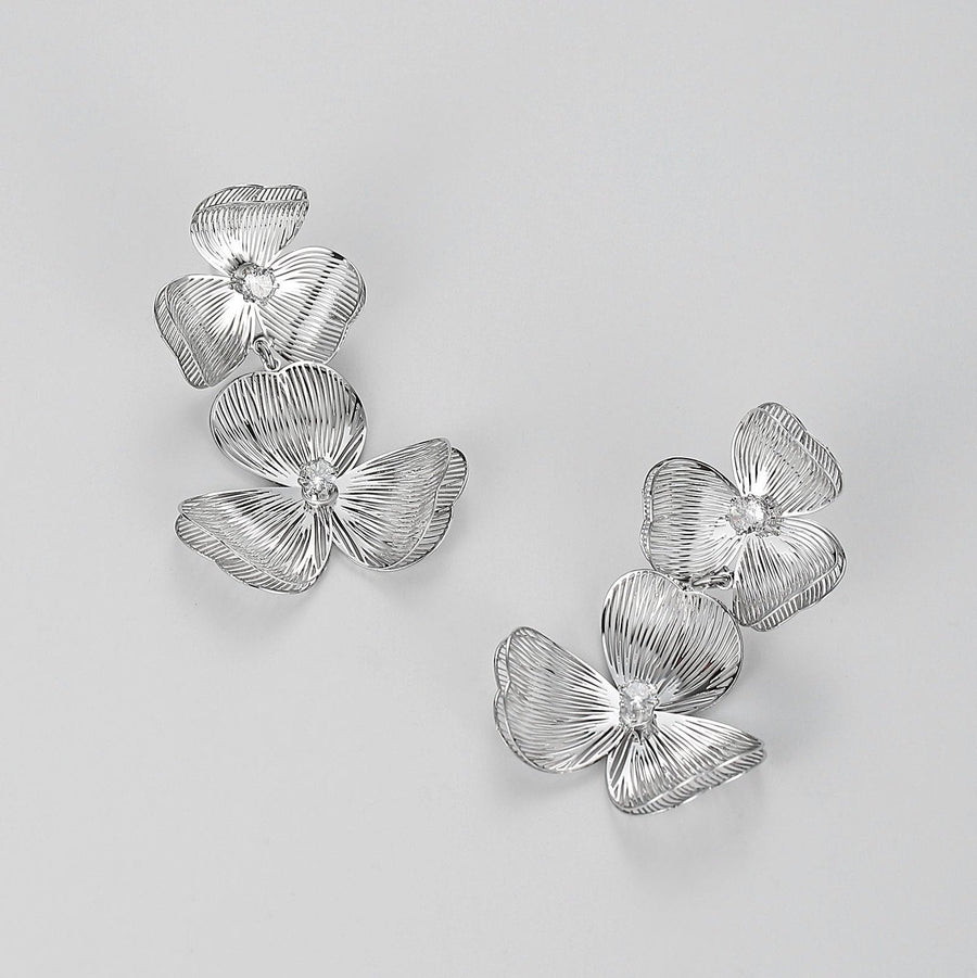 Each earring features two blossoms - one larger and one smaller - linked in harmonious beauty. The petals boast an incredibly lifelike texture that captures the delicate folds and curves found in nature’s own creations. 