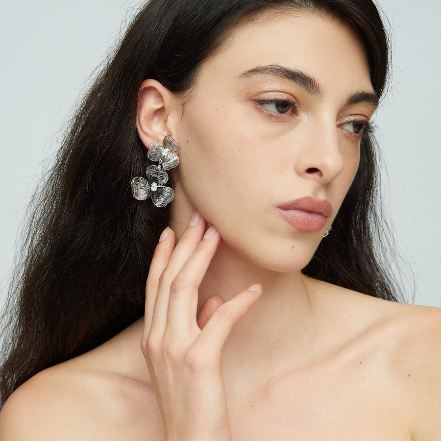 Each earring features two blossoms - one larger and one smaller - linked in harmonious beauty. The petals boast an incredibly lifelike texture that captures the delicate folds and curves found in nature’s own creations. 