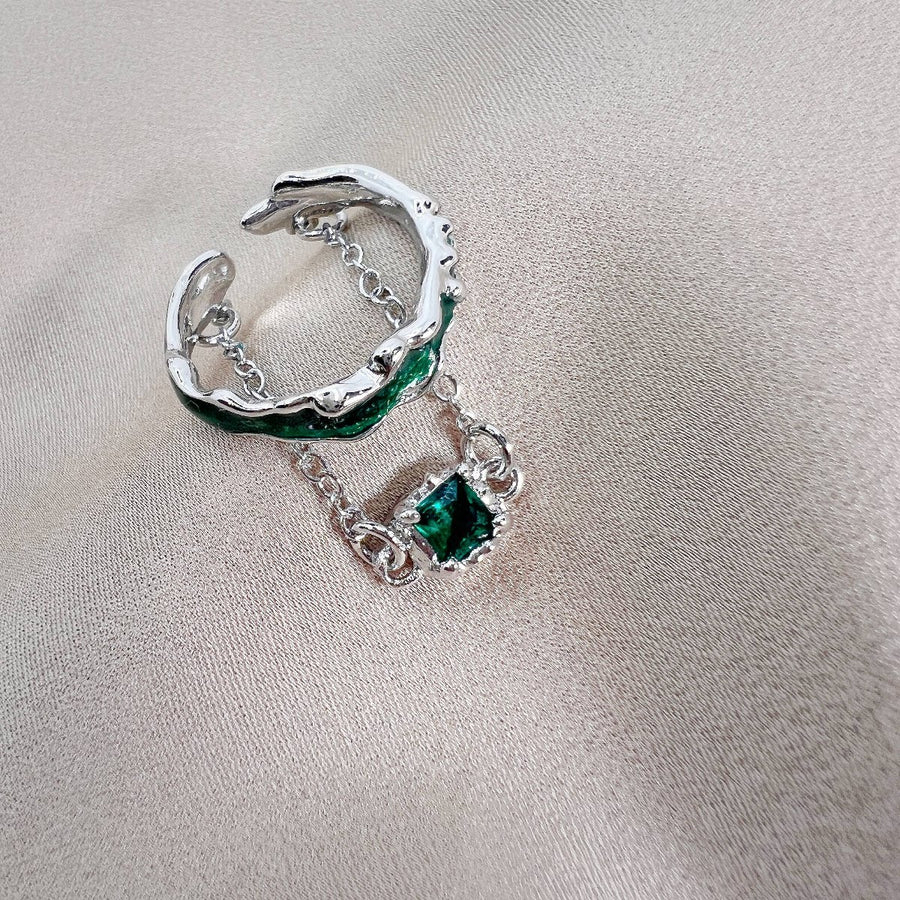 This sterling silver ring features a unique and intricate design, showcasing a beautiful emerald green zircon as its centerpiece. Perfect for those who appreciate a touch of individuality in their accessories. 