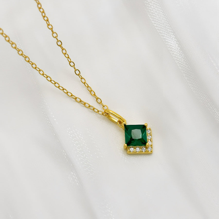 This elegant 925 silver necklace features a delicate gold chain and a striking pendant. The pendant showcases a square-cut green cubic zircon, framed by a border of small, sparkling diamonds cubic zircon, adding a touch of sophistication and luxury to any outfit. Perfect for any occasion, this necklace is a timeless piece that enhances both everyday and special event looks with its vibrant and refined design.