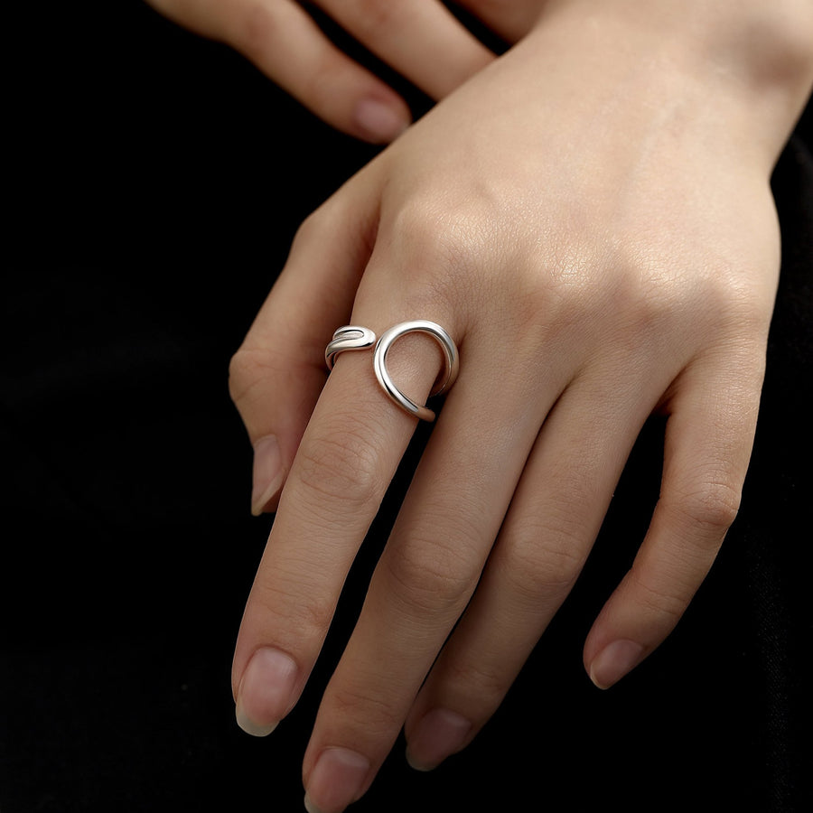 This silver ring features an elegant, flowing design inspired by the infinity symbol, representing timelessness and boundless possibilities.