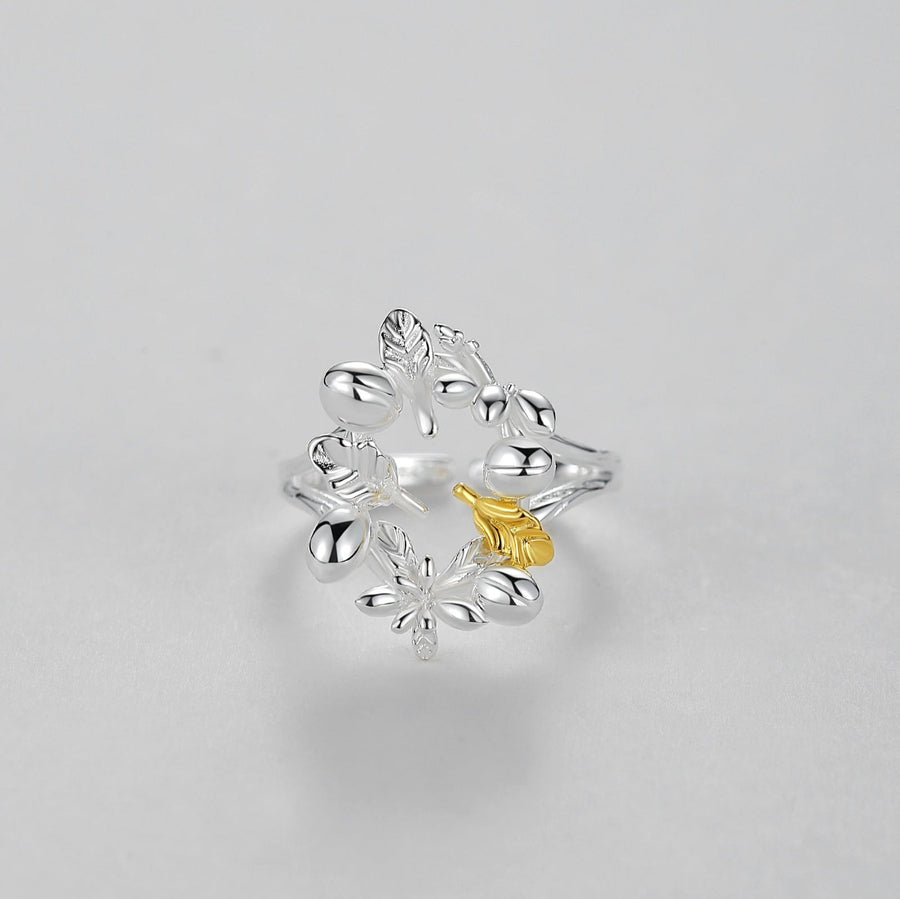 925 Sterling silver ring.  The ring features an intricate pattern of flowers and leaves, creating a delicate and elegant appearance. One leaf is highlighted with a gold-tone accent, adding a touch of contrast and visual interest to the overall design.