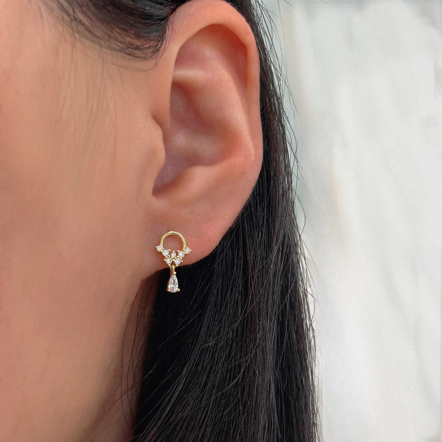 These exquisite earrings feature a delicate gold hoop adorned with sparkling cubic zircon, culminating in a stunning teardrop-shaped cubic zircon dangle. Perfect for adding a touch of elegance and sophistication to any outfit, these earrings are a timeless addition to any jewelry collection. 