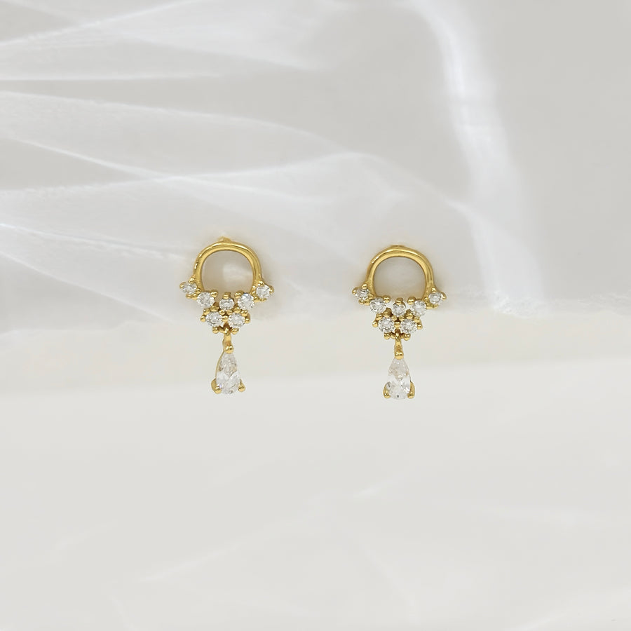 These exquisite earrings feature a delicate gold hoop adorned with sparkling cubic zircon, culminating in a stunning teardrop-shaped cubic zircon dangle. Perfect for adding a touch of elegance and sophistication to any outfit, these earrings are a timeless addition to any jewelry collection. 