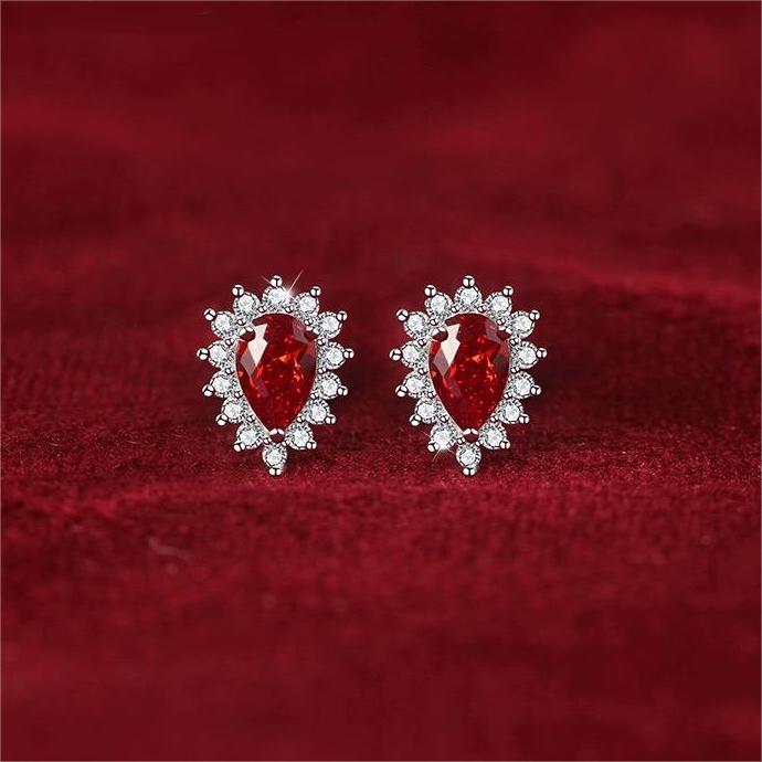 Elevate your elegance with these teardrop-shaped silver stud earrings, showcasing a stunning red cubic zircon encircled by dazzling cubic zircon accents. A timeless design that adds a touch of glamour to any outfit.