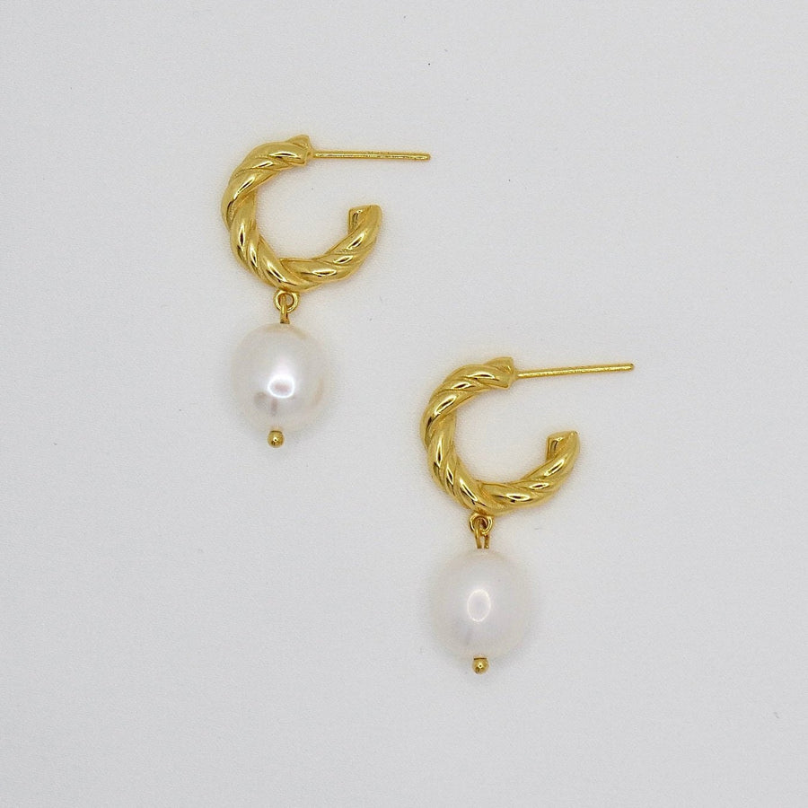 The 925 silver earrings feature a delicate 18K gold-plated twisted hoop paired with an elegant baroque pearl drop. Combining classic charm and contemporary style, these earrings bring sophistication and natural beauty to any look. Perfect for both casual elegance and formal occasions.