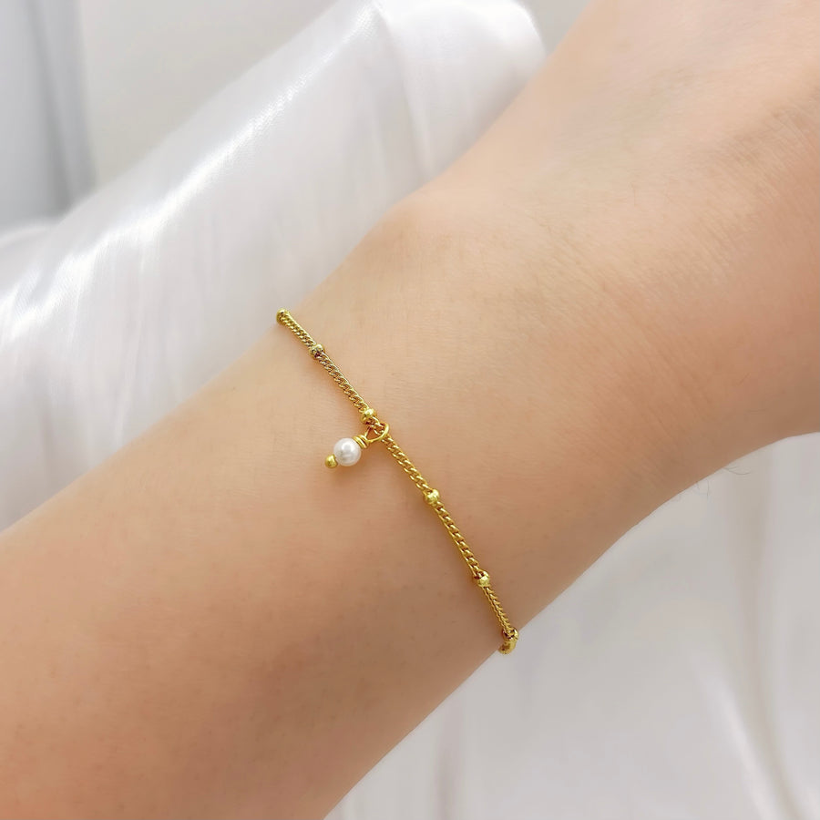 This elegant gold vermeil bracelet features delicate bead details and a charming pearl drop, adding a touch of sophistication to your style. Crafted with precision and adorned with subtle accents, this bracelet is perfect for everyday wear or special occasions.