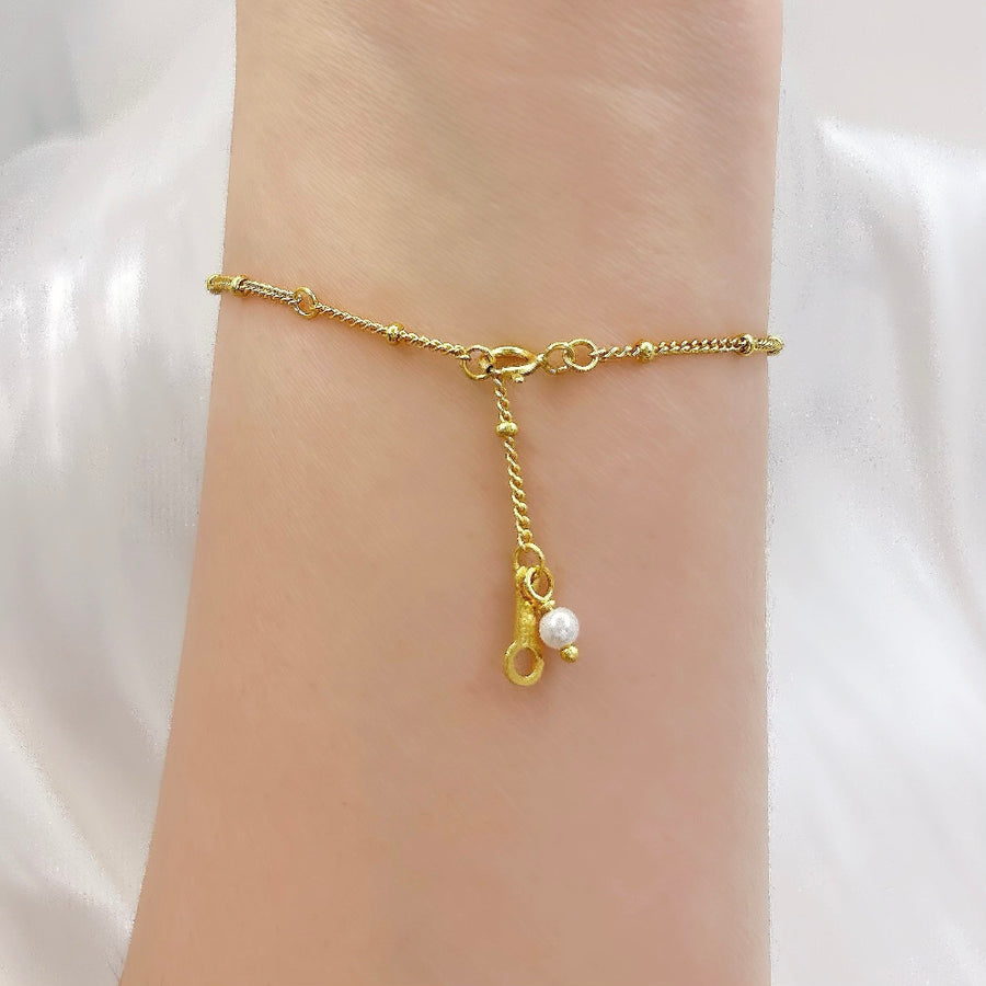 This elegant gold vermeil bracelet features delicate bead details and a charming pearl drop, adding a touch of sophistication to your style. Crafted with precision and adorned with subtle accents, this bracelet is perfect for everyday wear or special occasions.