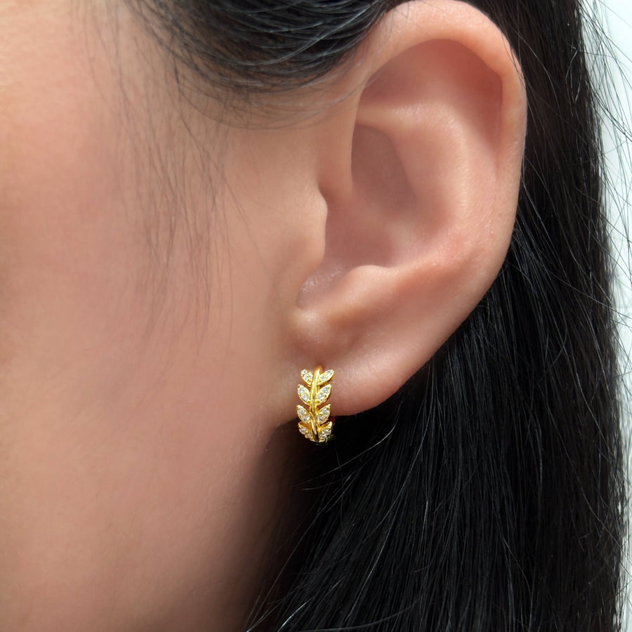 These exquisite gold earrings feature a delicate leaf design adorned with sparkling cubic zircon, adding a touch of nature-inspired elegance. Perfect for both everyday wear and special occasions, they effortlessly elevate your style with a refined and luxurious finish. 