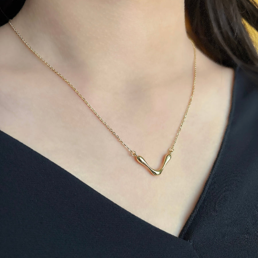 This stunning gold necklace features a unique, wave-like pendant that exudes modern elegance and artistic flair. The fluid design adds a touch of sophistication to any outfit. Crafted with precision, this necklace is perfect for both casual and formal occasions, making it a versatile and timeless addition to your jewelry collection.