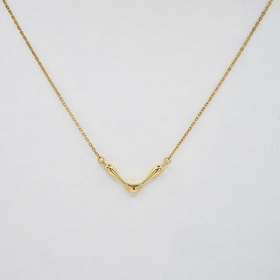 This stunning gold necklace features a unique, wave-like pendant that exudes modern elegance and artistic flair. The fluid design adds a touch of sophistication to any outfit. Crafted with precision, this necklace is perfect for both casual and formal occasions, making it a versatile and timeless addition to your jewelry collection.