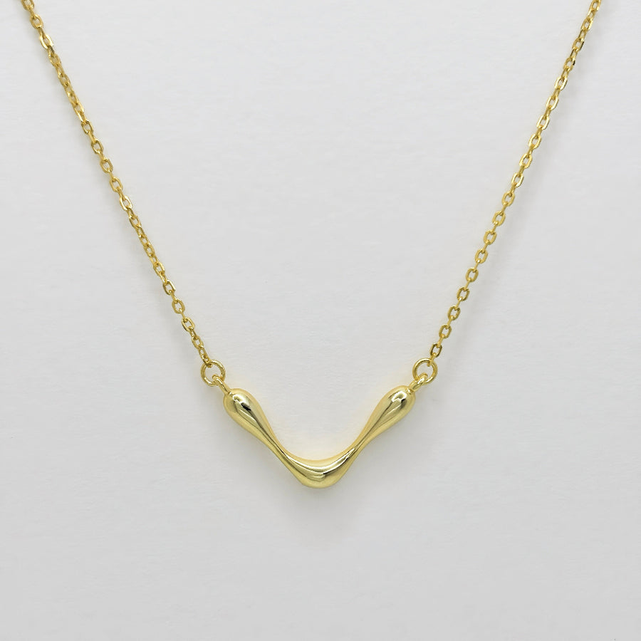 This stunning gold necklace features a unique, wave-like pendant that exudes modern elegance and artistic flair. The fluid design adds a touch of sophistication to any outfit. Crafted with precision, this necklace is perfect for both casual and formal occasions, making it a versatile and timeless addition to your jewelry collection.