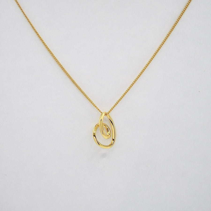 This elegant silver necklace features a delicate gold chain and a unique, abstract heart-shaped pendant. The pendant's fluid, organic design adds a modern twist to a classic symbol of love, making it a perfect accessory for any occasion. 