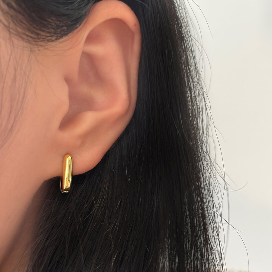 These elegant gold hoop earrings feature a sleek, modern design that effortlessly complements any outfit. The polished finish and minimalistic style make these hoops a versatile addition to both casual and formal looks.