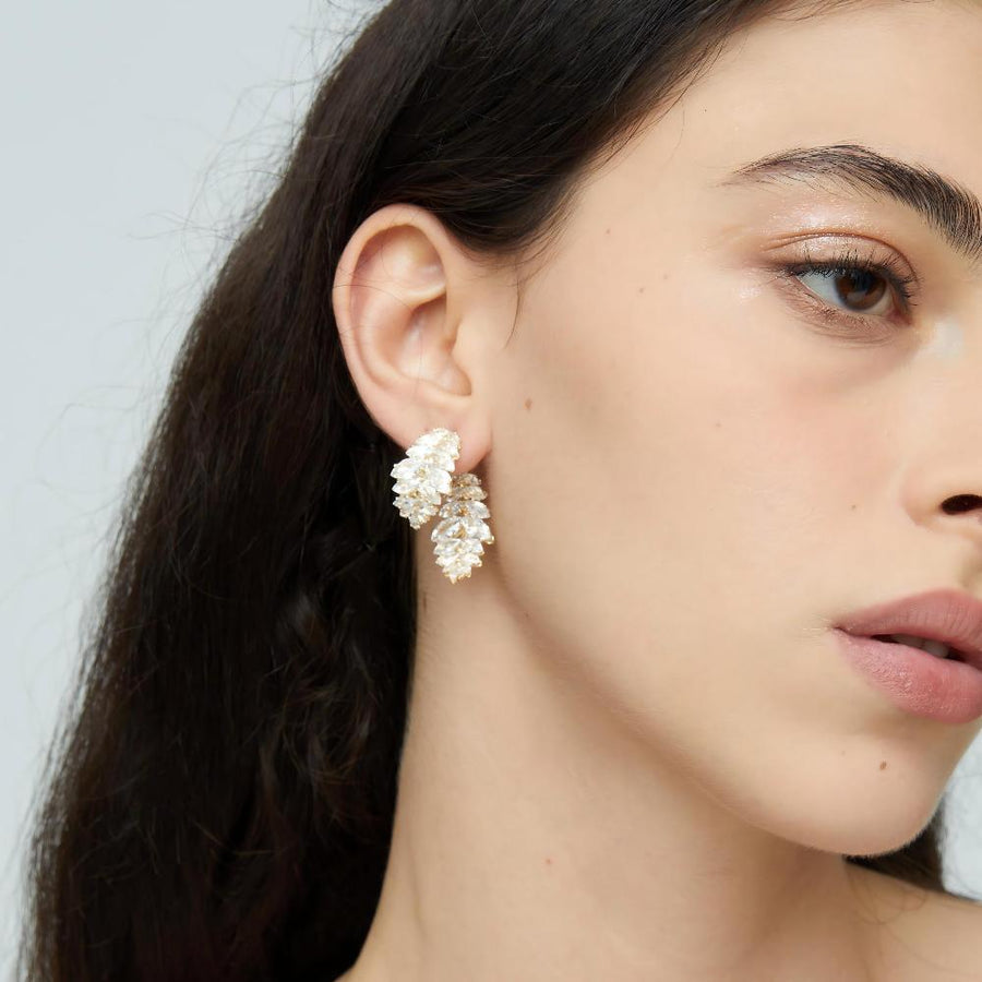 Each earring features a unique design of two overlapping leaf shapes, intricately adorned with sparkling olive-shaped cubic zirconia. Perfect for special occasions or to elevate your everyday style, these earrings are a must-have for anyone who loves detailed and opulent accessories.