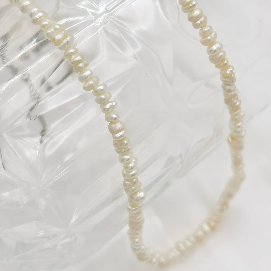 Elevate your style with this elegant mini freshwater pearl necklace, featuring naturally shaped pearls for a timeless, sophisticated look. Crafted with care, this versatile piece adds a touch of charm to both casual and formal outfits, making it a must-have in your jewelry collection.