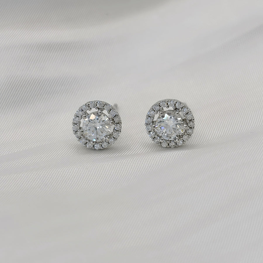 925 silver earrings. These dazzling stud earrings feature a brilliant round-cut centerpiece surrounded by a halo of sparkling cubic zirconia. Perfectly crafted in a sleek silver-tone finish, they exude timeless elegance for any occasion.