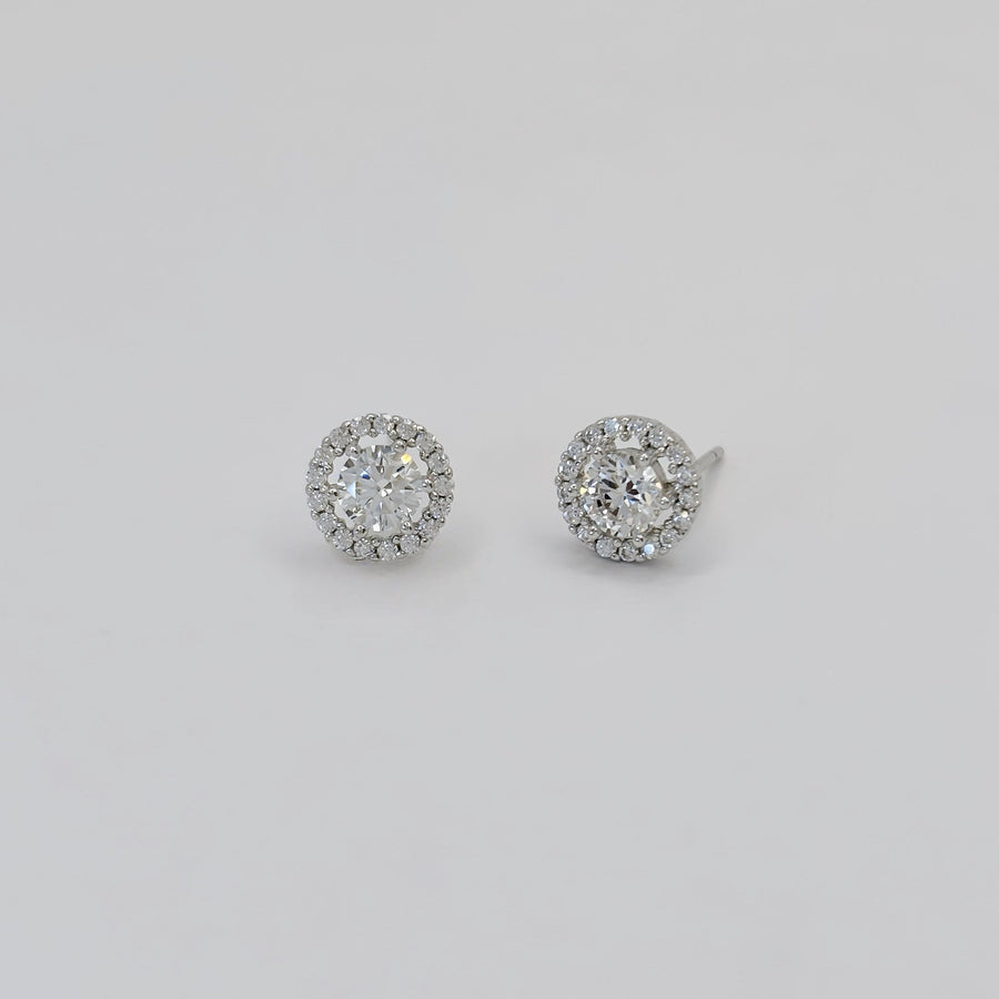 925 silver earrings. These dazzling stud earrings feature a brilliant round-cut centerpiece surrounded by a halo of sparkling cubic zirconia. Perfectly crafted in a sleek silver-tone finish, they exude timeless elegance for any occasion.