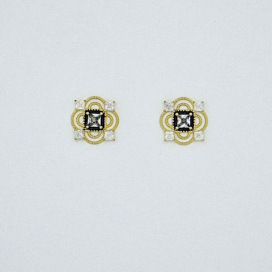 These vintage-inspired silver stud earrings feature a striking black square framed by intricate gold details and shimmering cubic zirconia accents. Perfect for adding a touch of glamour and sophistication to any outfit. 