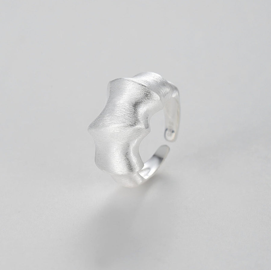 Adjustable Ring. Crafted from premium quality silver, this ring features a unique open band design, creating an abstract and artistic look. The brushed finish adds a contemporary touch, enhancing the ring’s artistic appeal. 