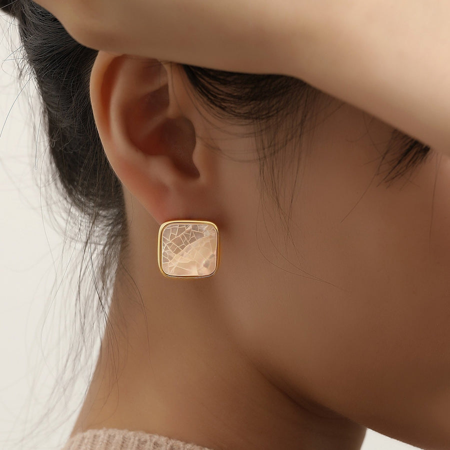 These exquisite studs showcase a lustrous mother-of-pearl centerpiece, beautifully framed in a polished gold-tone setting, adding a touch of timeless elegance to any look. Perfect for both everyday wear and special occasions, these earrings bring a subtle yet sophisticated shine to your jewelry collection.