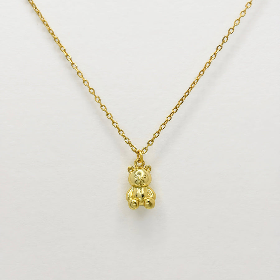 This adorable silver necklace features a charming teddy bear pendant crafted from high-quality gold vermeil, making it a perfect accessory for adding a touch of whimsy and elegance to any outfit. The delicate gold chain complements the intricate details of the teddy bear, creating a timeless piece that is both playful and sophisticated.