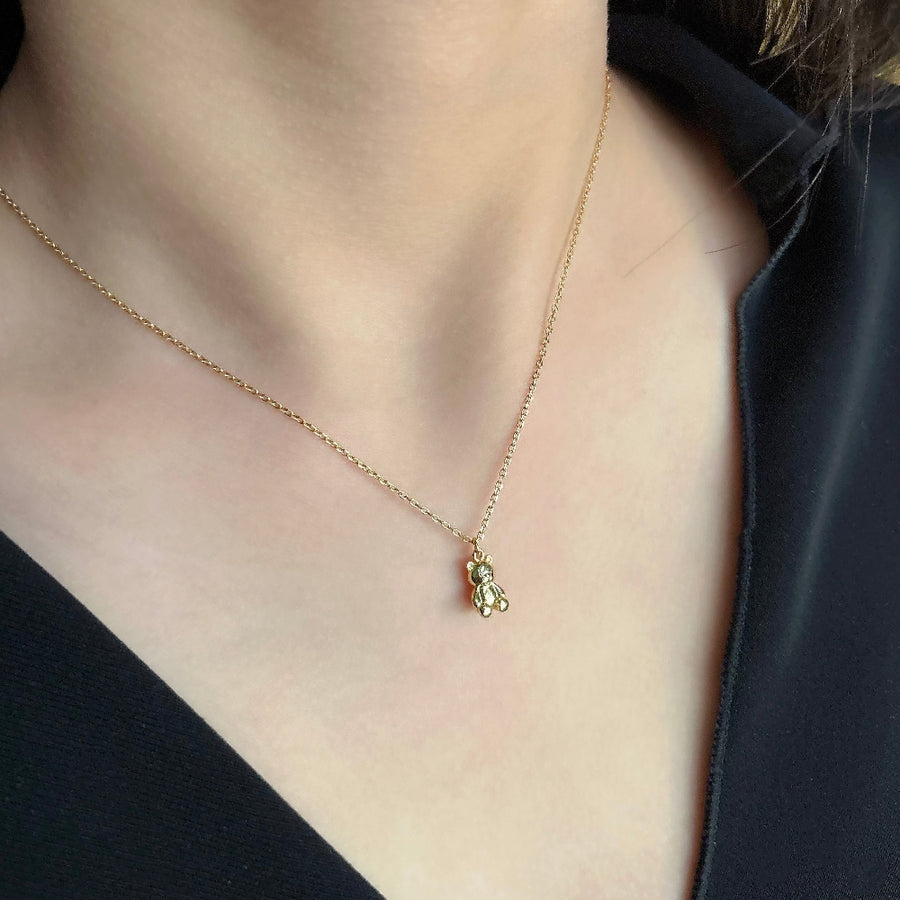 This adorable silver necklace features a charming teddy bear pendant crafted from high-quality gold vermeil, making it a perfect accessory for adding a touch of whimsy and elegance to any outfit. The delicate gold chain complements the intricate details of the teddy bear, creating a timeless piece that is both playful and sophisticated.