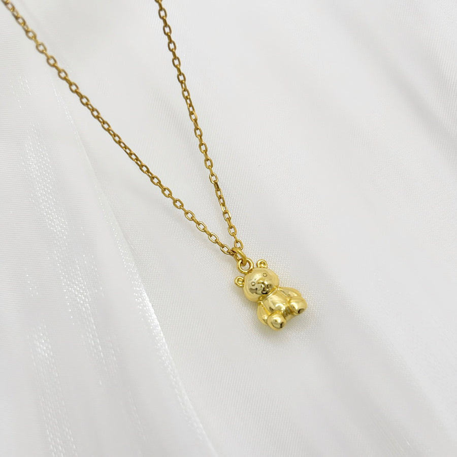 This adorable silver necklace features a charming teddy bear pendant crafted from high-quality gold vermeil, making it a perfect accessory for adding a touch of whimsy and elegance to any outfit. The delicate gold chain complements the intricate details of the teddy bear, creating a timeless piece that is both playful and sophisticated.