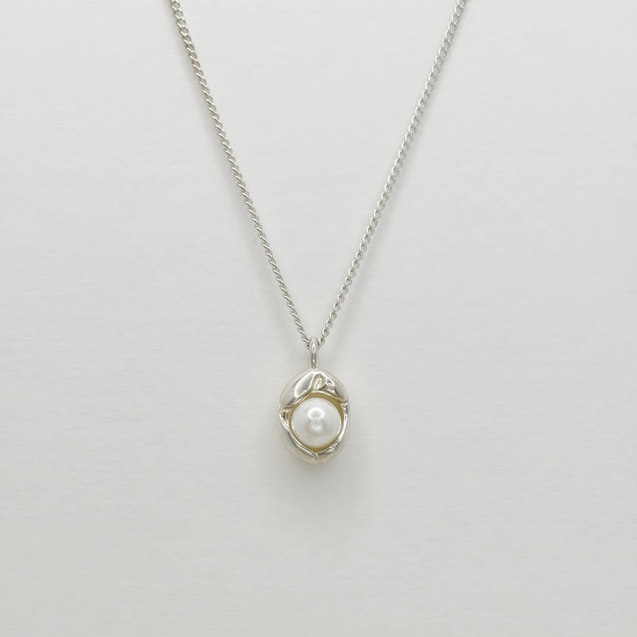 This silver necklace features a pendant adorned with lustrous, round white pearls, elegantly shaped like an irregular pod, exuding vivacious charm and timeless elegance. Its versatile design makes it suitable for a wide range of occasions, and its ageless appeal makes it perfect for individuals of all ages to wear, adding a touch of sophistication to any ensemble.