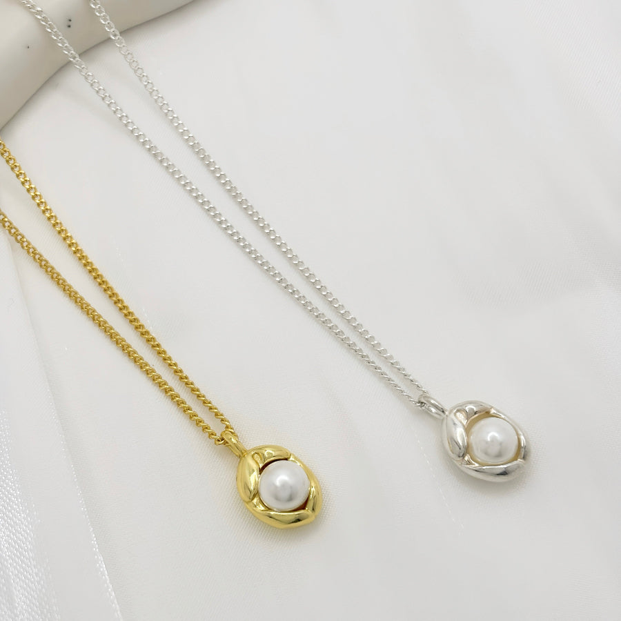 This silver necklace features a pendant adorned with lustrous, round white pearls, elegantly shaped like an irregular pod, exuding vivacious charm and timeless elegance. Its versatile design makes it suitable for a wide range of occasions, and its ageless appeal makes it perfect for individuals of all ages to wear, adding a touch of sophistication to any ensemble.