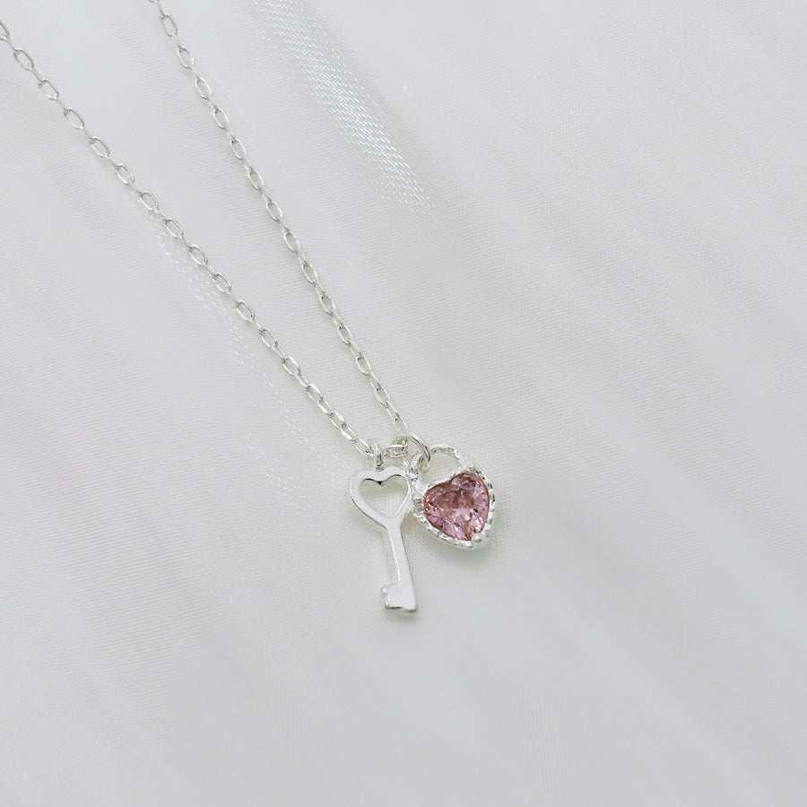 This 925 silver necklace features a stylish and enchanting design with dual pendants: a beautifully crafted pink cubic zirconia heart and a silver key. Its elegant and playful design makes it suitable for various occasions, exuding a sense of delicacy and charm. 