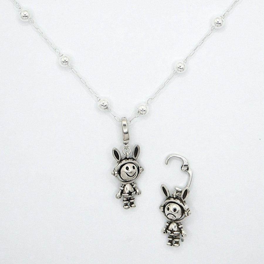 This necklace features a whimsical astronaut bunny with a double-sided, rotating face crafted from 925 sterling silver. With one side depicting a cheerful smile and the other showing a unhappy expression, it adds a playful and versatile touch to your jewelry collection. 